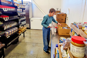 Volunteer organizing and stocking food items in a pantry to support community members in need through United Way programs.